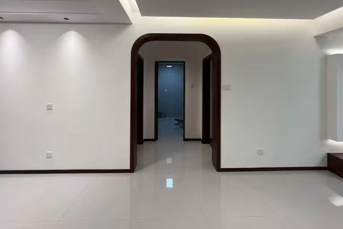 旺园小区改造后的客餐厅实景，圆角门洞与浅色空间改善通行和观感