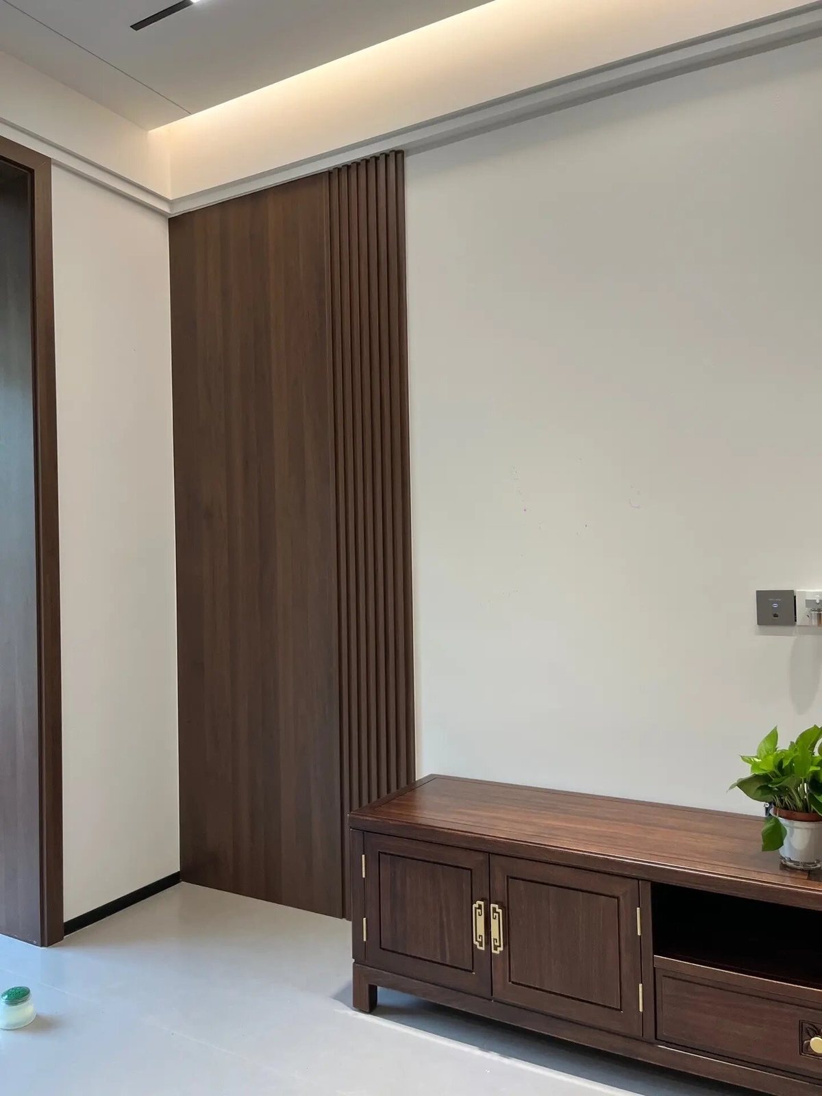 恒大国际城新中式客厅与阳台连通实景,窗边设置休闲座椅和到顶收纳柜
